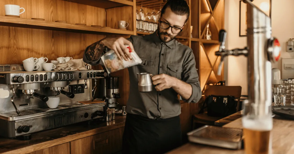 Barista preparando bebidas en su cafetería